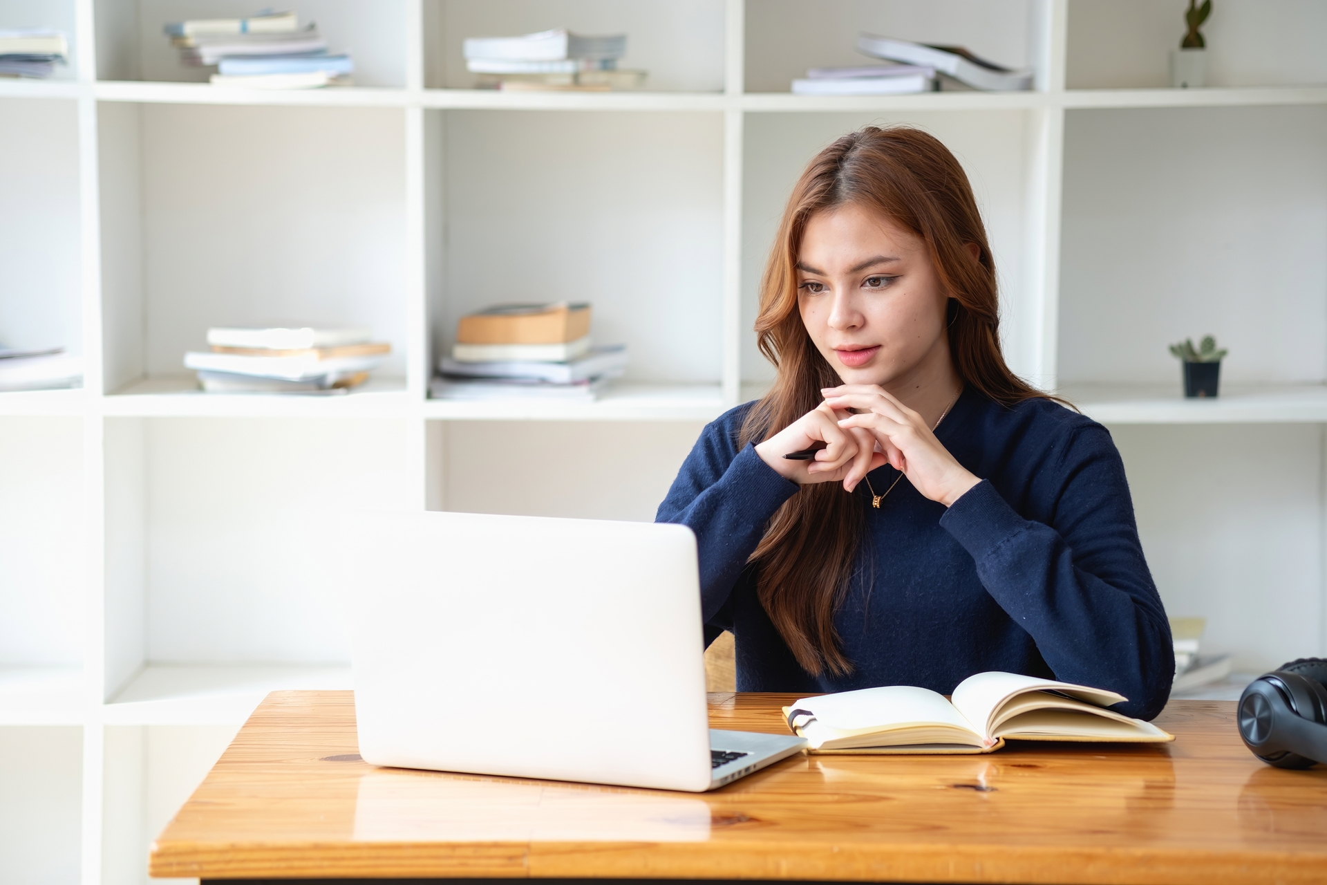 Happy young Latin female college student studying online remotely Distance university webinars Or video call on your laptop and use your computer for a virtual meeting seminar at home or on campus.